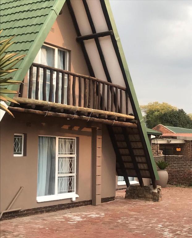 a balcony on the side of a house at Pomona Lodge in Kempton Park