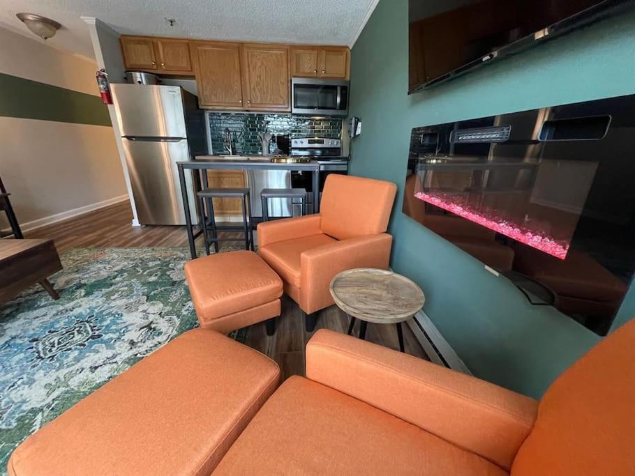 sala de estar con sillas de color naranja y cocina en Mountain Lodge getaway, ski-in/ski-out, heart of the village, en Snowshoe
