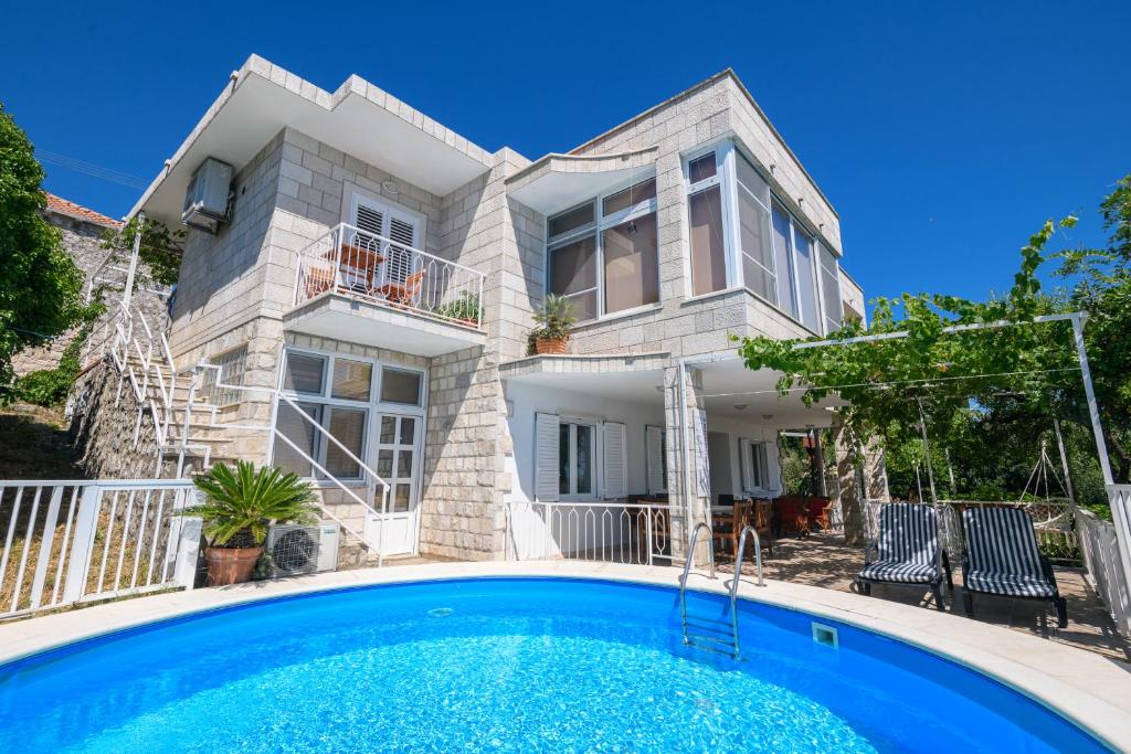 オラサックにあるApartment MARIO - veliki stan za odmor - terasa- vrt - bazen - pogled more, izoliranの正面にプールがある家