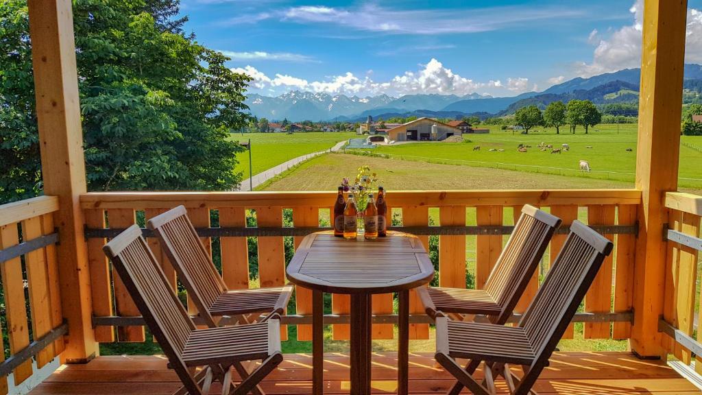 una mesa y sillas en una terraza con vistas a una granja en Ferienwohnung Hehl, en Burgberg