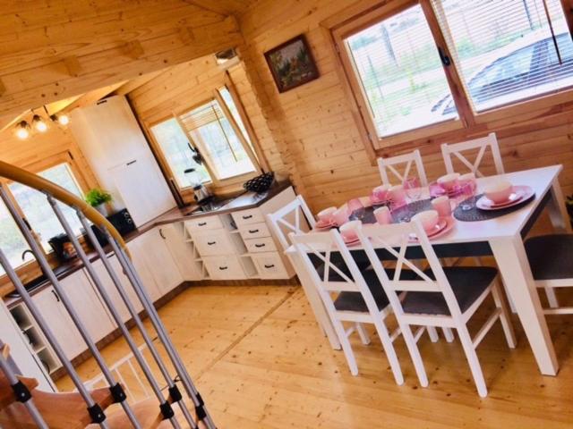 una cucina con tavolo e sedie in una cabina di Domek nad jeziorem 
