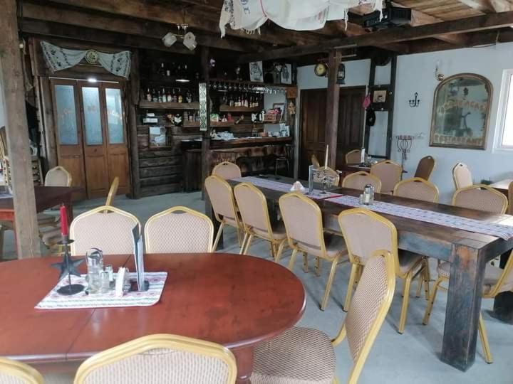 a dining room with a large wooden table and chairs at Cabana Dor de-Acas / Restaurant Dor de-Acas in Gura Haitii
