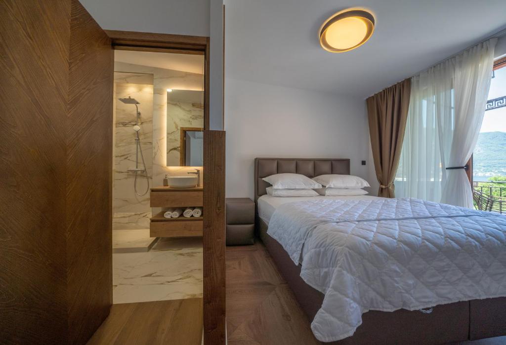 a bedroom with a bed and a bathroom with a shower at Apartments Nikčević in Kotor