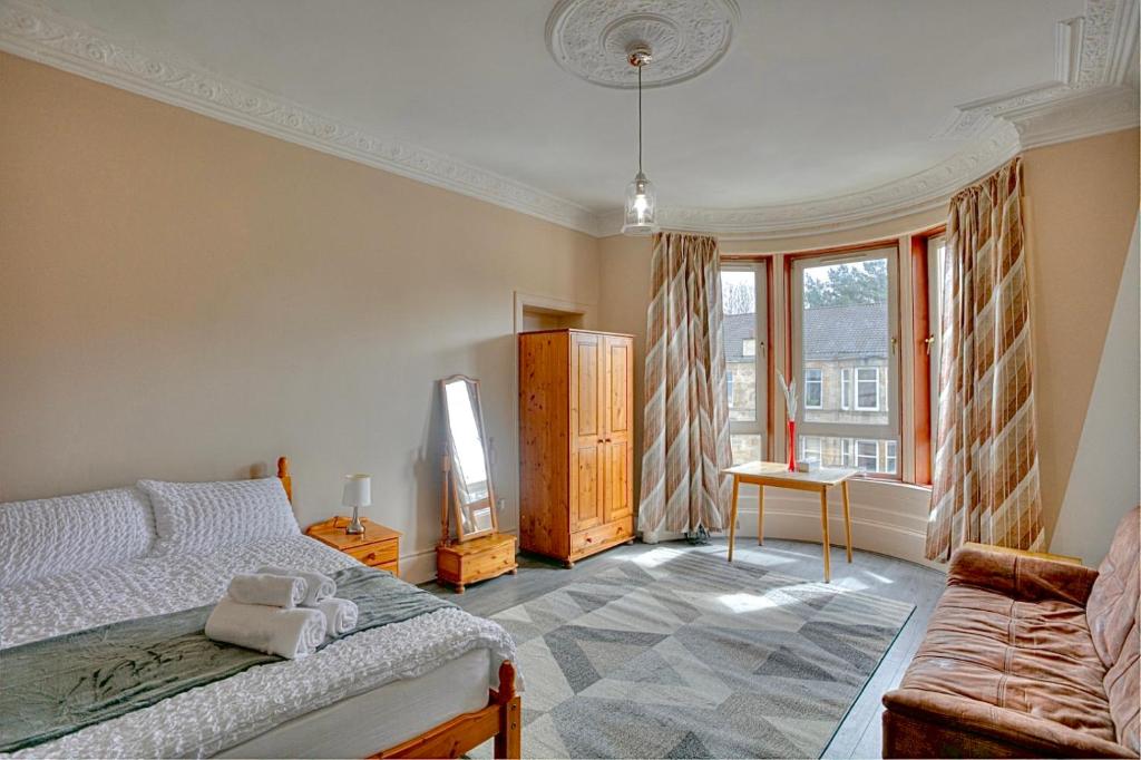 una camera con letto, divano e finestra di Spacious 3-Bed Apartment for Small Large Groups Close to BBC SSE Central Glasgow West End Free Parking a Glasgow