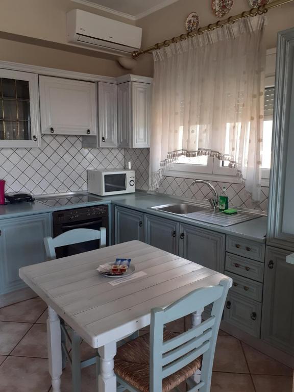 uma cozinha com uma mesa branca e um lavatório em Antoni's Rooms em Limenaria