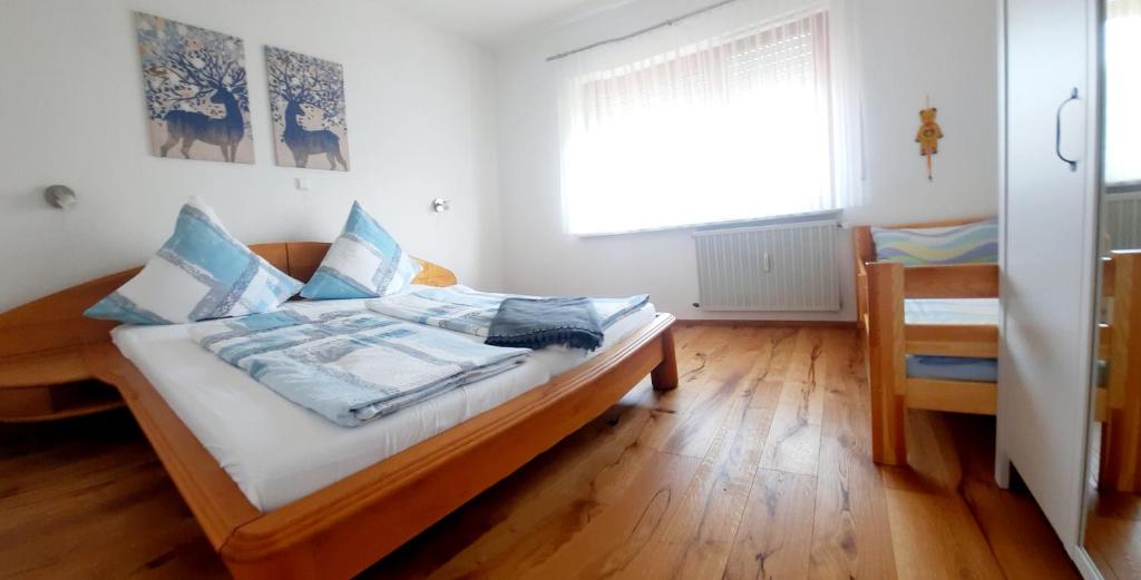 a bedroom with a bed with a wooden floor and a window at Appartement - FeWo Wenne in Langenau