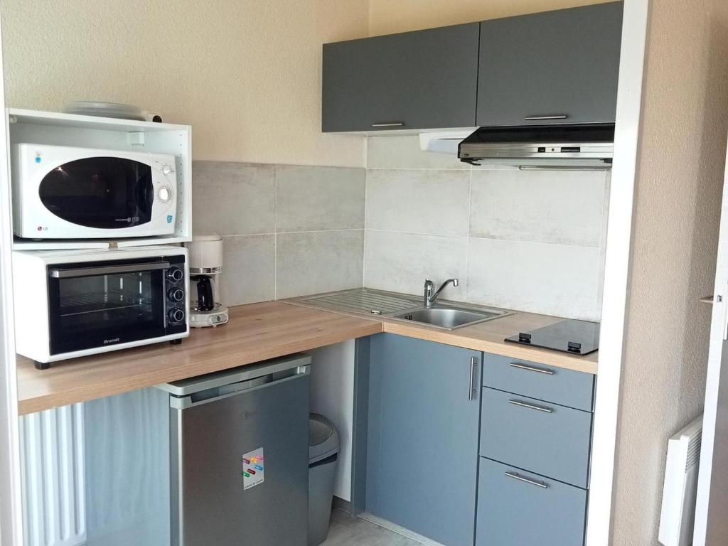 une petite cuisine avec un micro-ondes et un évier dans l'établissement Studio ensoleillé proche plage, 4 pers, La Rochelle - FR-1-551-38, à La Rochelle