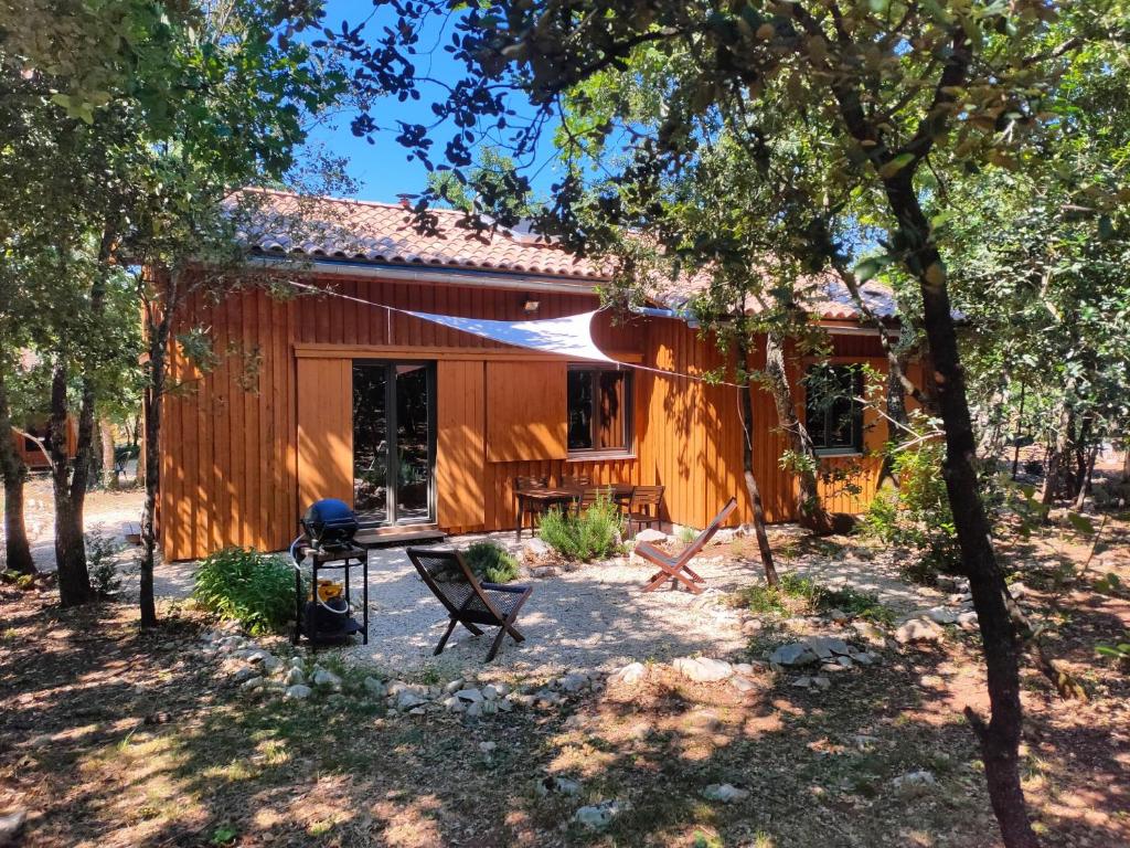 una cabaña en el bosque con mesa y sillas en Gite et cabane écologiques 1000 Pailles, en Labastide-de-Virac