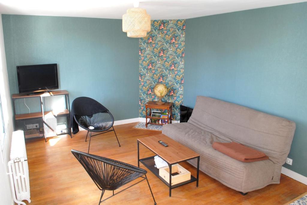 - un salon avec un canapé et une table dans l'établissement Maison 6 personnes - grand jardin arboré, à Noyers-sur-Cher