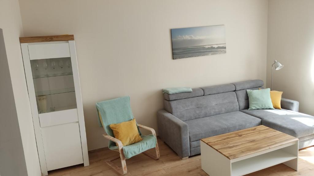 een woonkamer met een bank en een tafel bij Apartament Słoneczny Węgorzewo 74m2 in Węgorzewo