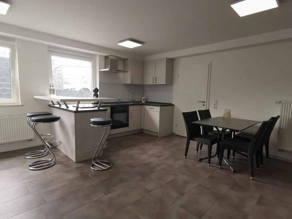 a kitchen with a table and chairs in a room at Moderne Wohnung mit Terrasse und eigenem Zugang. in Remscheid
