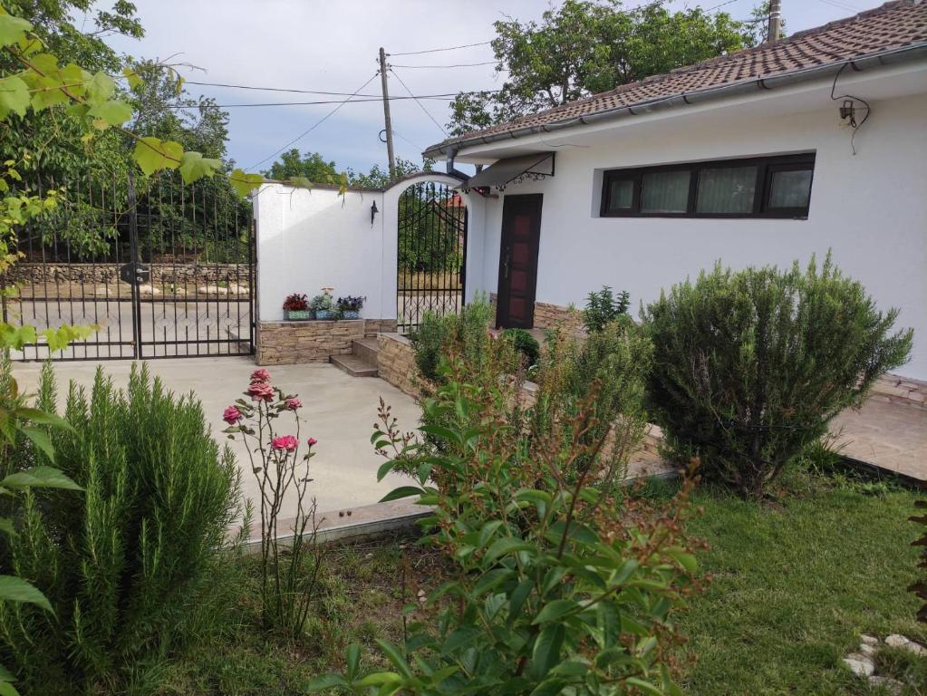 uma casa branca com um portão e um quintal em Studio Oasis-shabla em Shabla