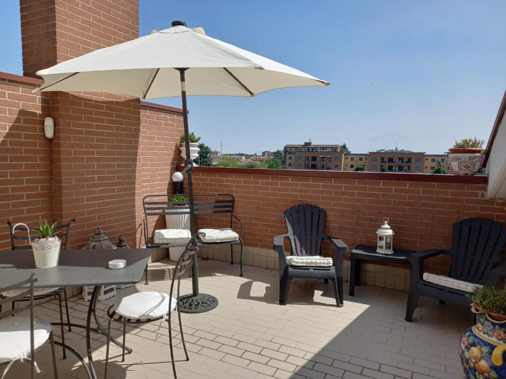 La mansarda di Mi&Lo junior suite في بولاّتي: فناء به طاولات وكراسي ومظلة