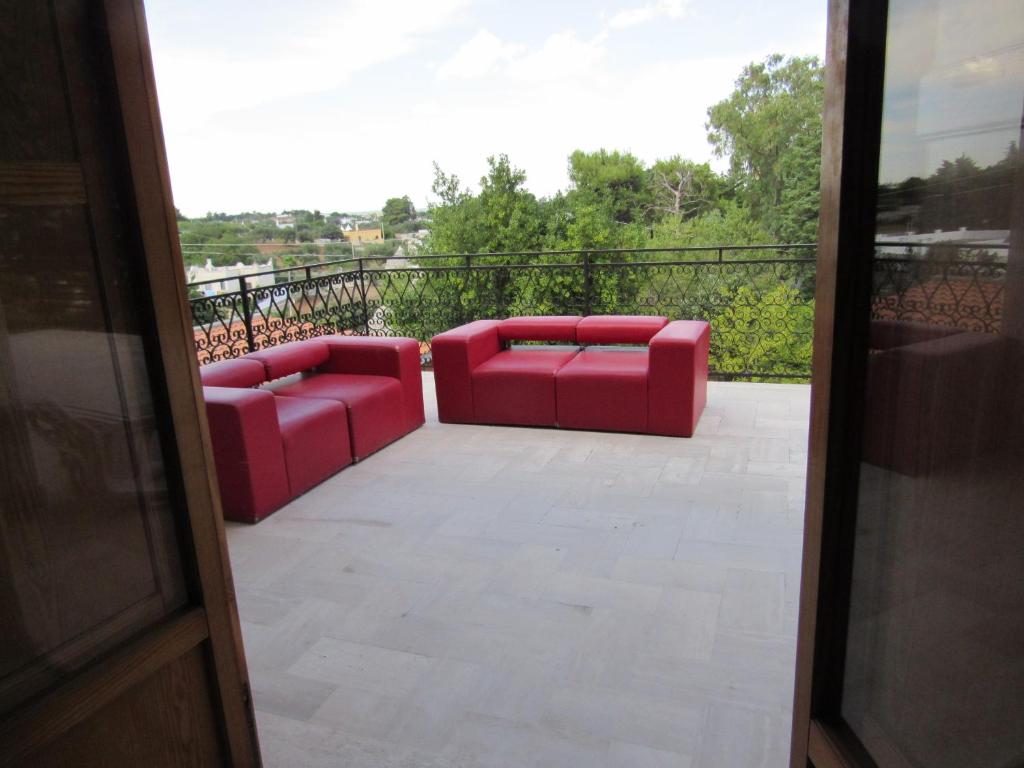two red couches sitting on a balcony at Casa il Giovane Alloro in Martina Franca