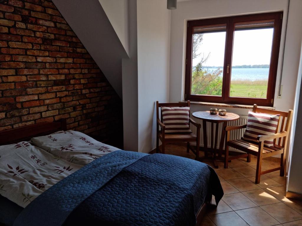 1 dormitorio con cama, mesa y ventana en Willa Etna, en Dziwnówek