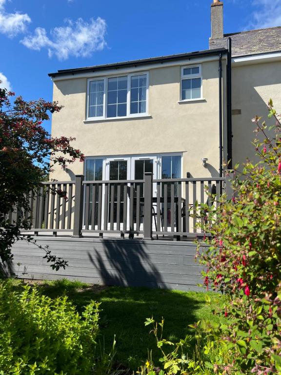 una casa con terraza de madera en el patio en The Haven at Halsons, en Bridport