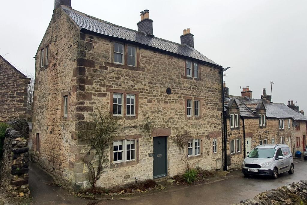 a car parked in front of a brick building at Candle House, Winster, in the Peak District in Winster