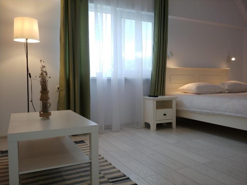 sypialnia z łóżkiem, oknem i stołem w obiekcie Casa Calin w mieście Crișan
