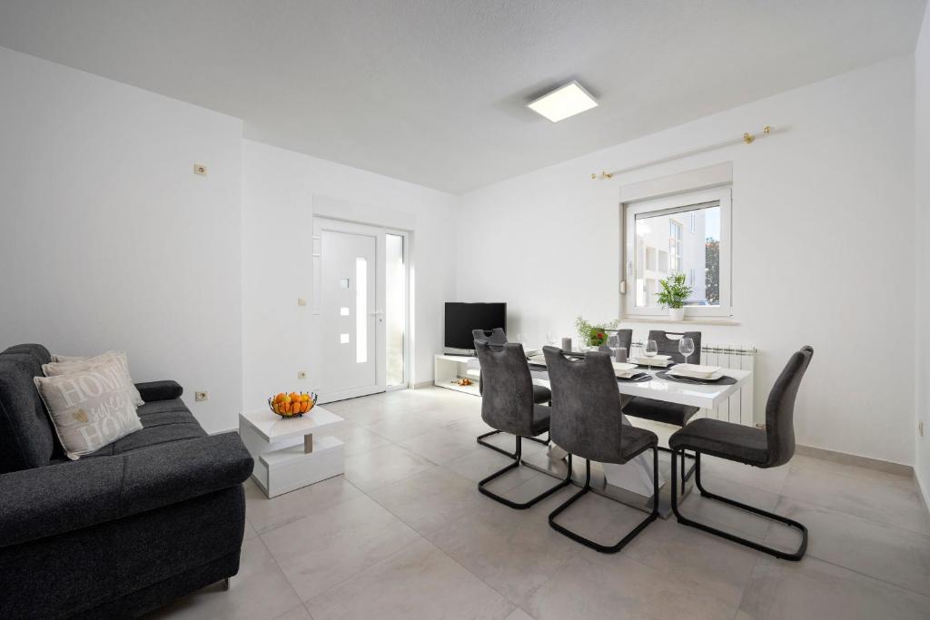 a living room with a couch and a table and chairs at Luxury apartment Ketty in Split