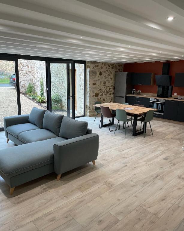 un salon avec un canapé et une table dans l'établissement Gîte de la Foye - Le Jasmin, à Combrand