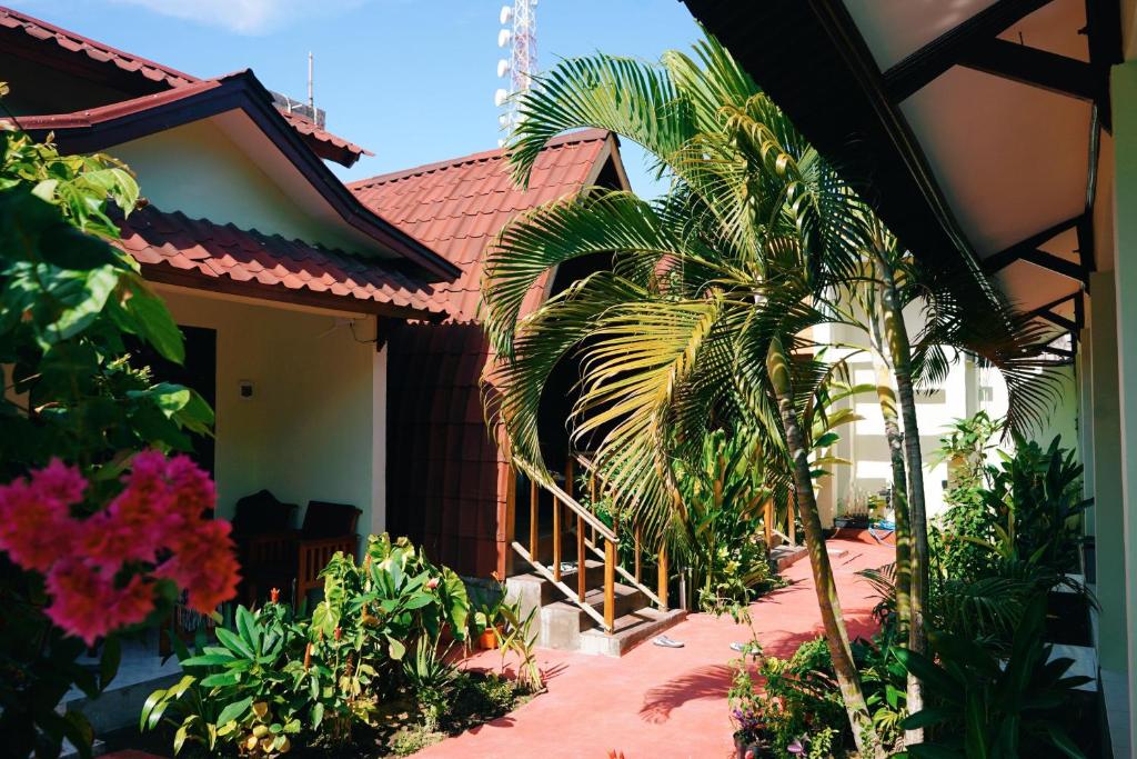 una casa con una palmera delante de ella en Gili Mesari Cottages & Homestay, en Gili Trawangan