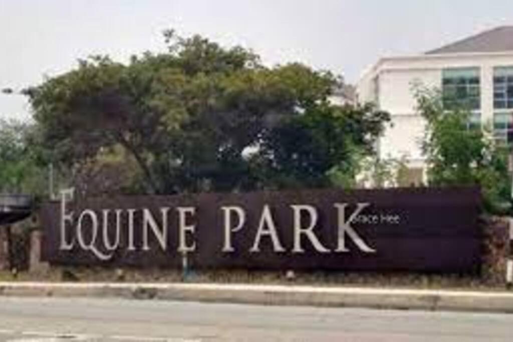 Un cartel que anuncia un parque infantil frente a un edificio. en Equine Park, Seri Kembangan, en Seri Kembangan