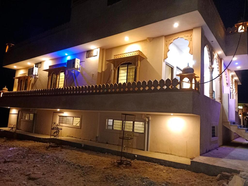 a large white building with a balcony at night at The Vantage Haveli in Sawāi Mādhopur