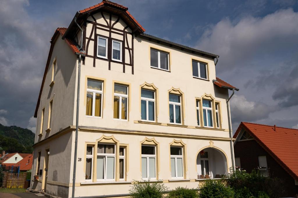 ein großes weißes Haus mit einem Gameradach in der Unterkunft Ferienwohnung am Steinbach 2 in Thale