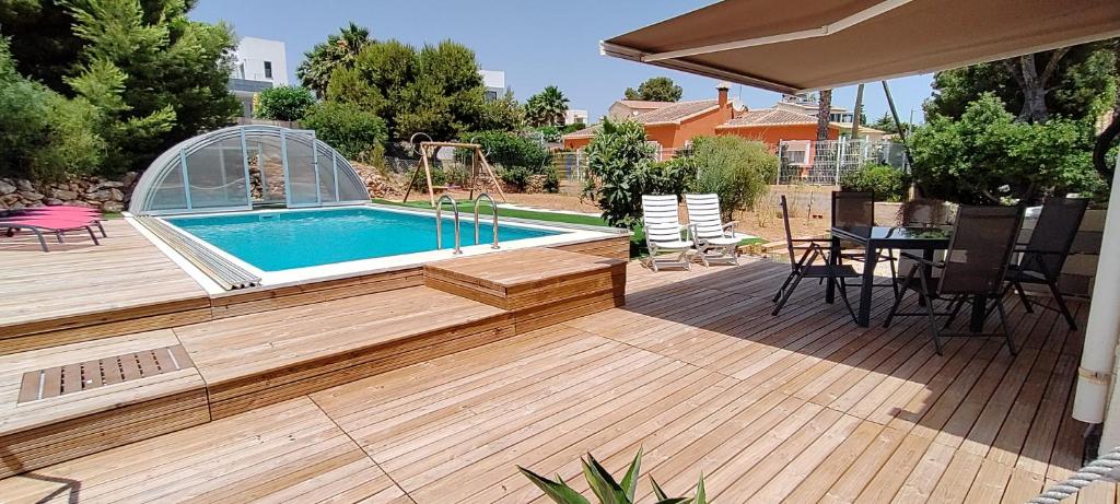 una terraza con piscina, mesa y sillas en Villa Las Ardillas, en Calpe