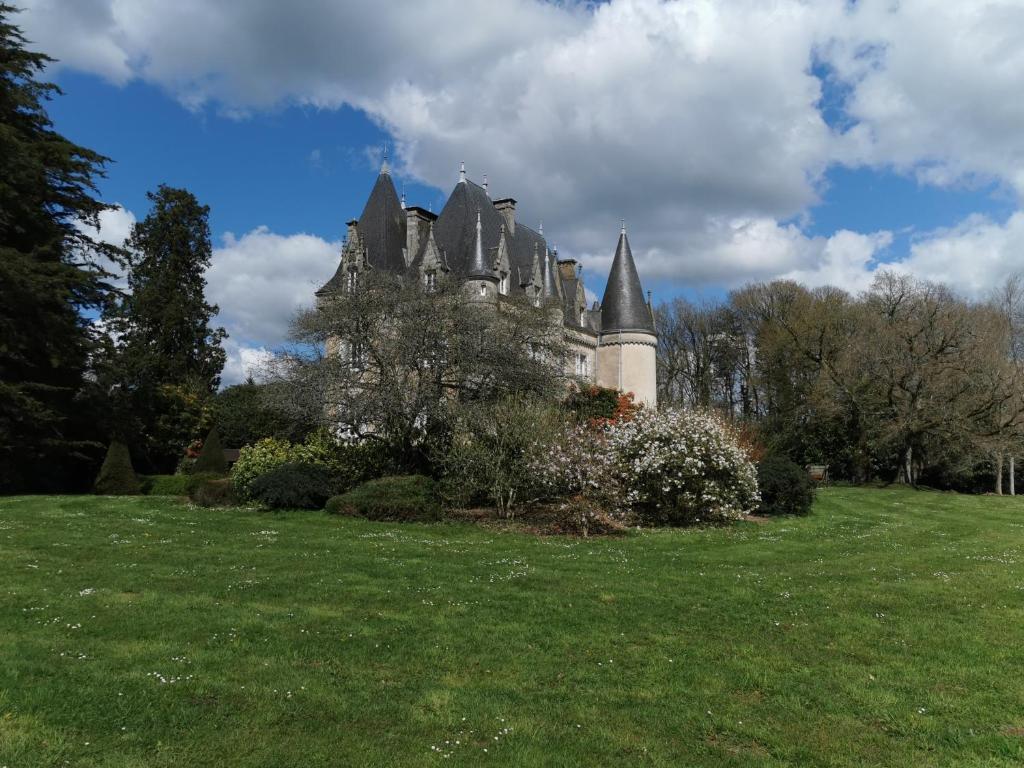 ein Schloss auf einem üppigen grünen Feld in der Unterkunft Château de Launay Guen in Plémet