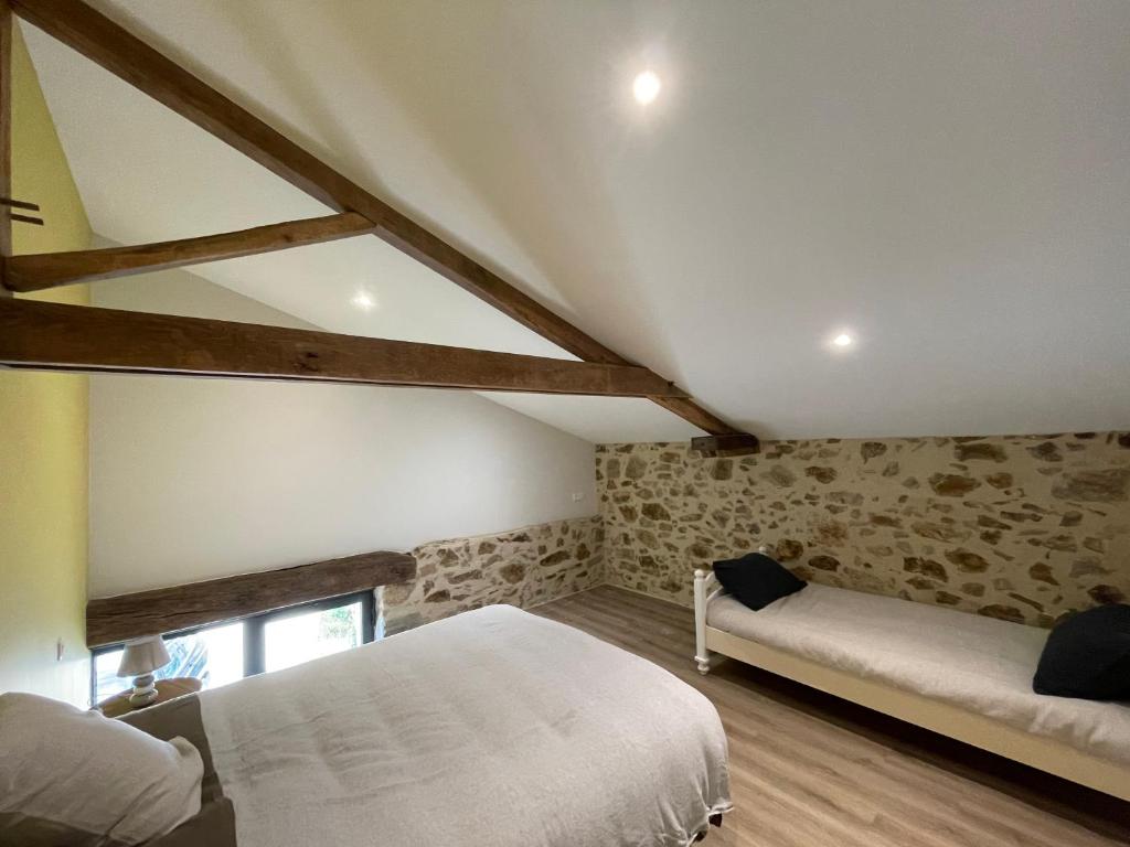 a bedroom with two beds in a attic at Gîte de la Foye - Le Jasmin in Combrand