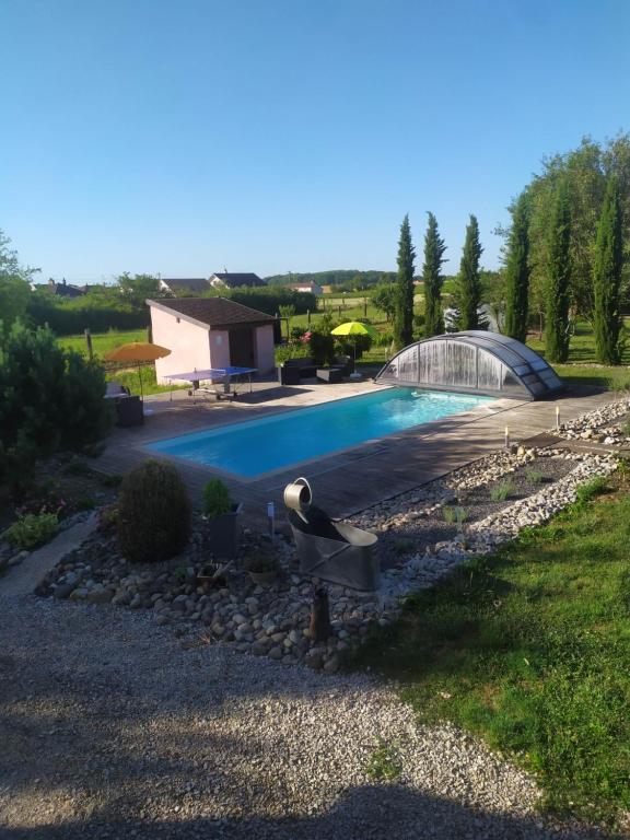 a swimming pool in a yard next to a house at Clos des chenevières, 3 étoiles in Comblanchien