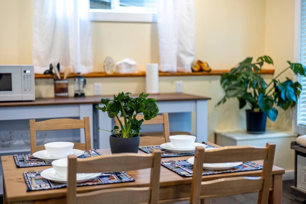 a table with chairs and plates on it in a kitchen at Adorable private suite with indoor fire place in Cochrane