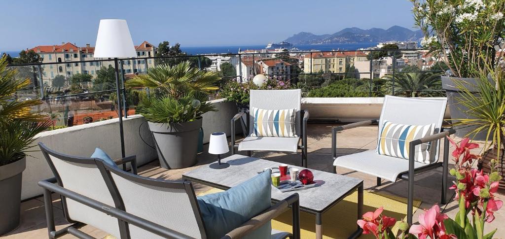 uma varanda com cadeiras e mesas num telhado em Sea view Penthouse with terrace em Cannes