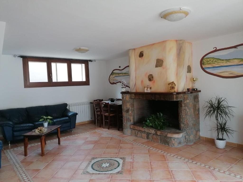 a living room with a fireplace and a couch at Casa vacanze Lilly in Teulada