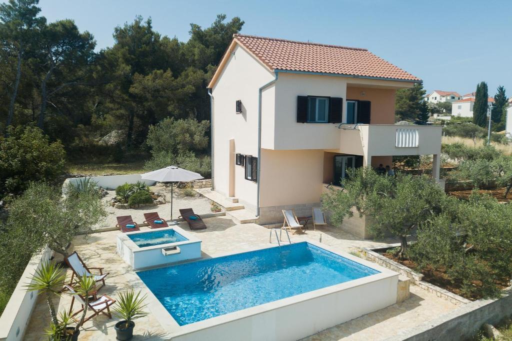 a villa with a swimming pool and a house at Holiday Home Tanja in Sutivan