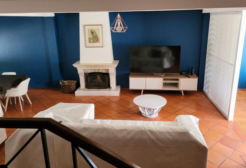 a living room with a tv and a fireplace at Parfum de la Mer in Sines