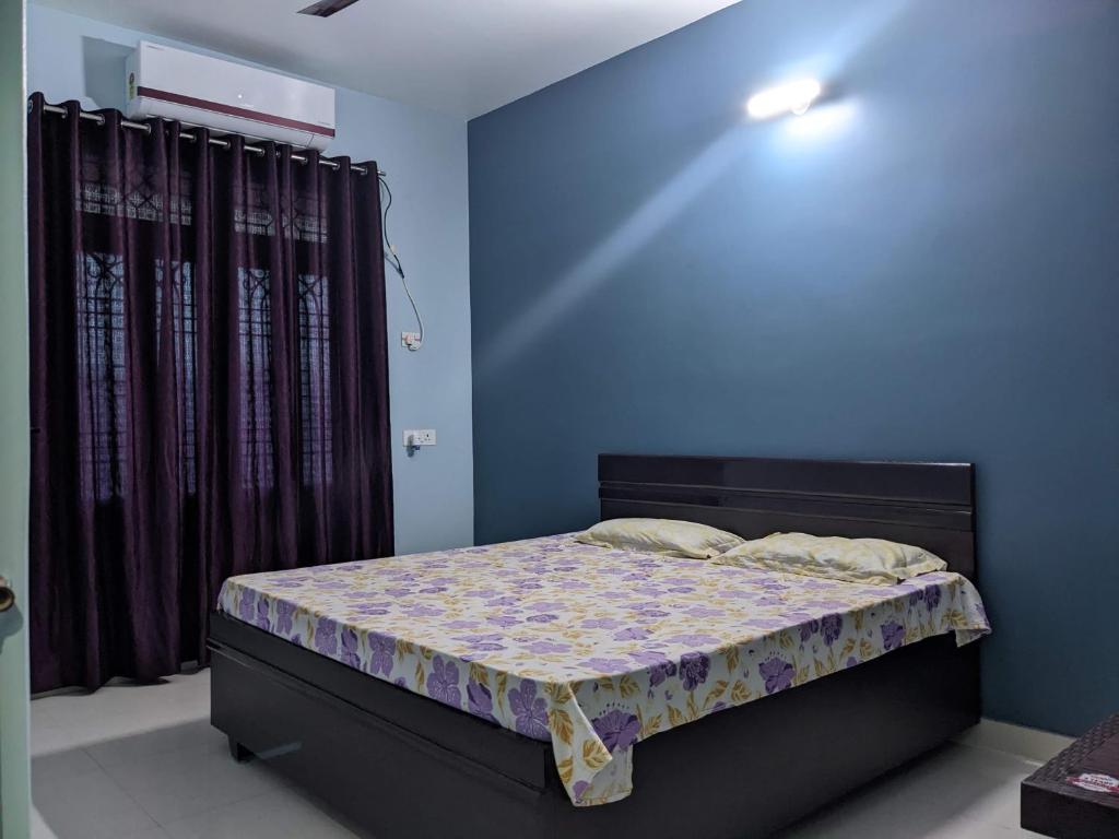 a bedroom with a bed with a blue wall at Swapnil Homestay in Varanasi