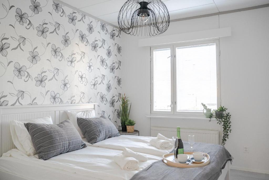 um quarto com uma cama branca e um papel de parede florido em West Coast Hideaway em Pietarsaari