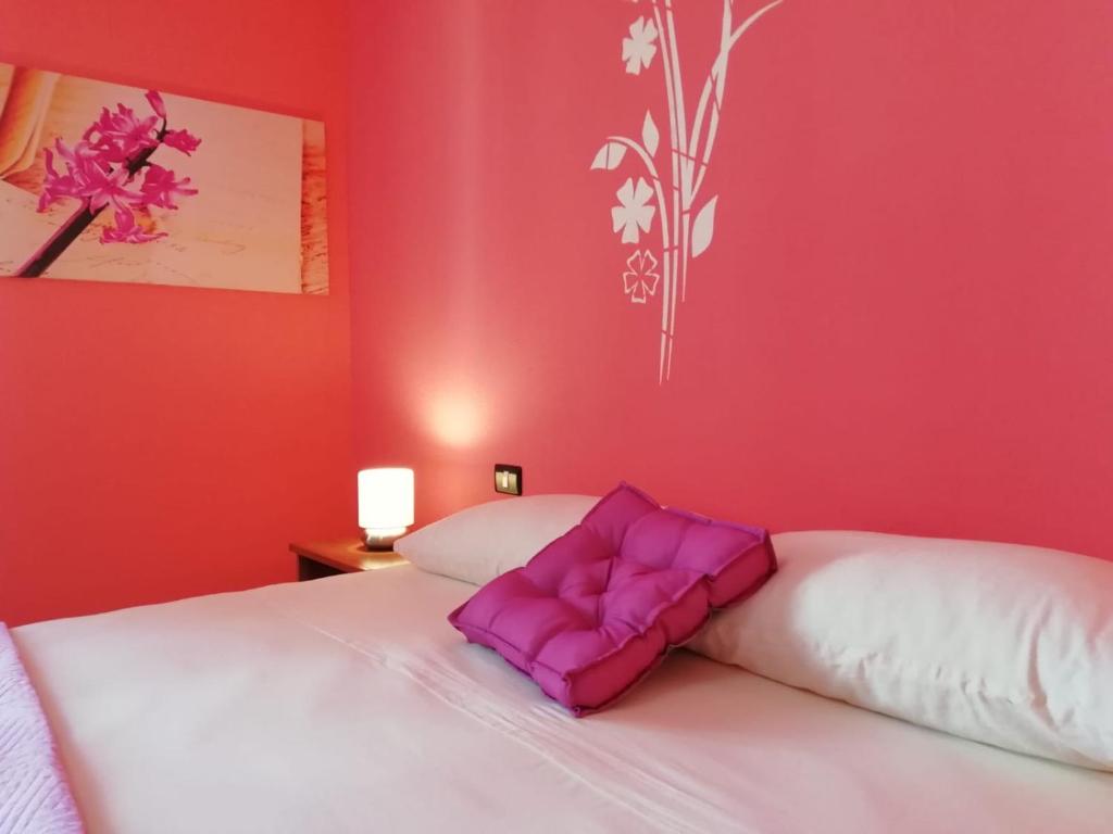 1 dormitorio con 2 camas con almohadas moradas en Prendas Antigas - vacanze a Teulada en Teulada