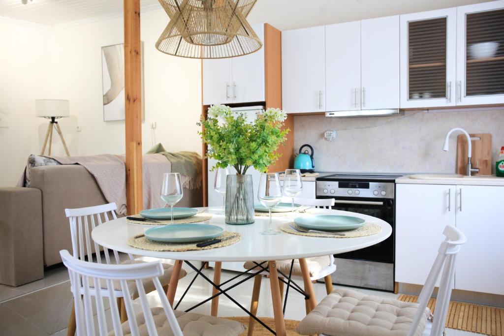 a kitchen with a white table with chairs and a dining room at LAXD Summer House by Homebrain in Makri