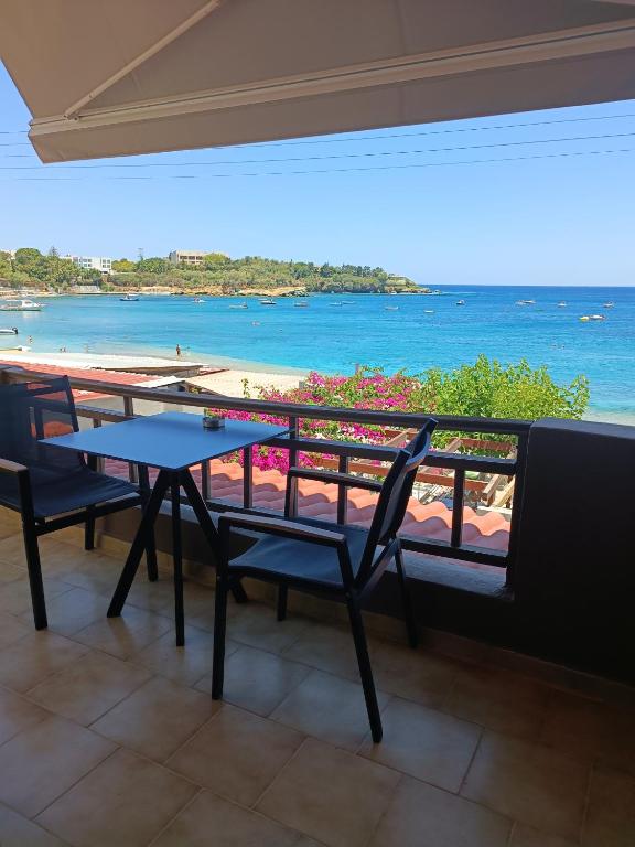 einen Tisch und Stühle auf einem Balkon mit Blick auf den Strand in der Unterkunft Buganvilla Sea View apts in Agia Pelagia