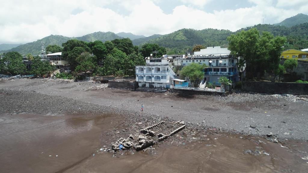 un groupe de bâtiments sur la rive d'une rivière dans l'établissement Océanis Hotel, à Mutsamudu