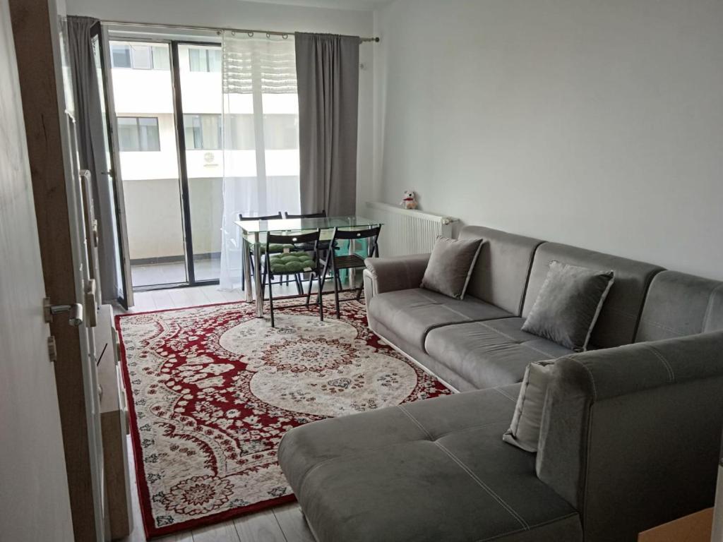 - un salon avec un canapé et une table dans l'établissement Deluxe 2 bedroom apartment with balcony and private parking, à Bragadiru