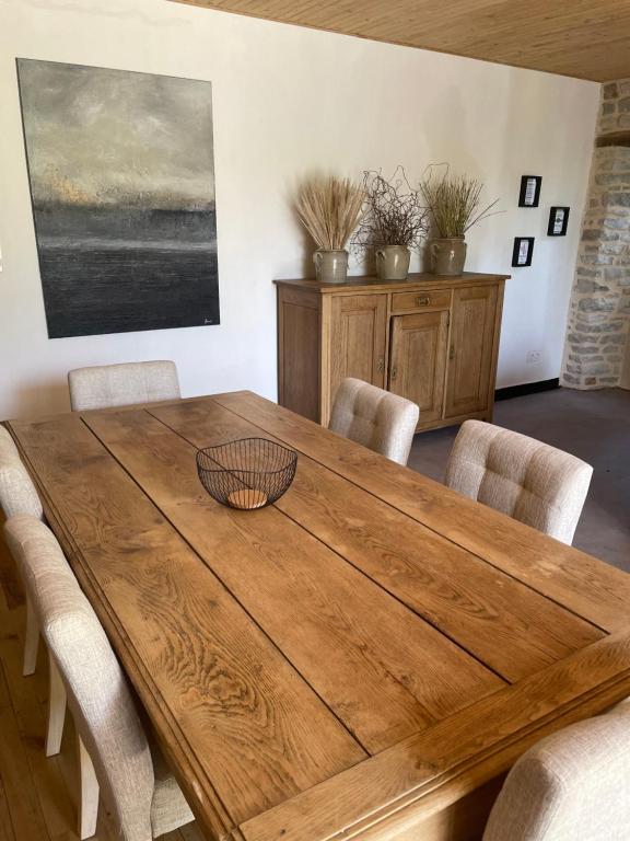 ein Esszimmer mit einem Holztisch und Stühlen in der Unterkunft La maison de Badet in Bozouls