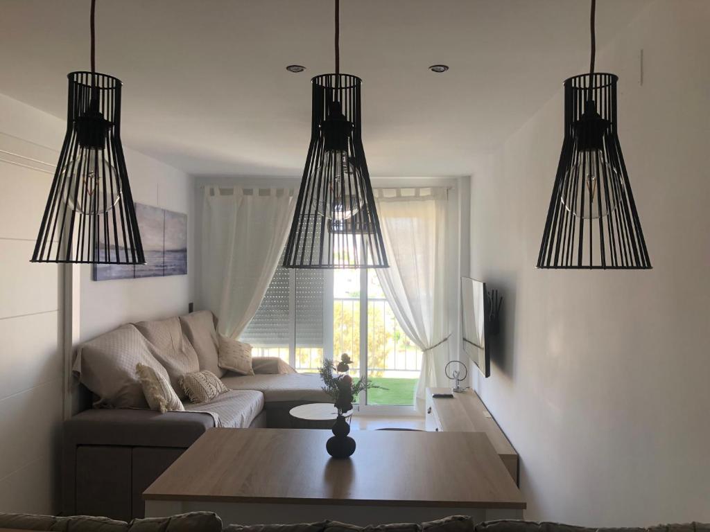 una sala de estar con 3 lámparas de araña colgando del techo en Vcc Home’s, en Puerto de Mazarrón