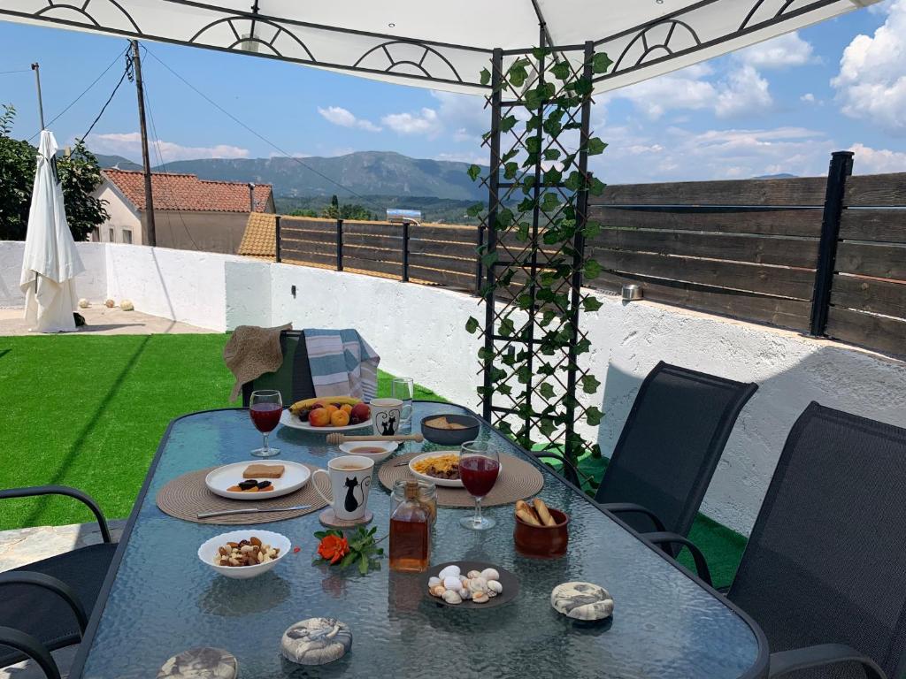 uma mesa com comida e copos de vinho num pátio em Family Country House-Corfu Holidays em Kanakádes