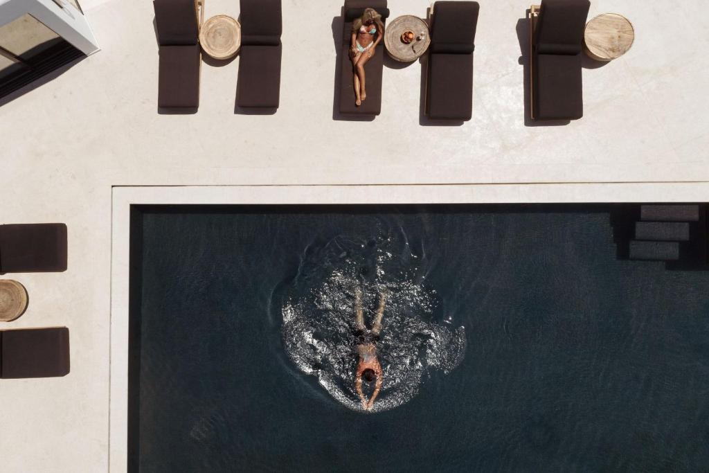 eine Aussicht auf eine Person, die im Wasser schwimmt in der Unterkunft Asty Mykonos Hotel & Spa - World of One Hotel Group in Mykonos Stadt