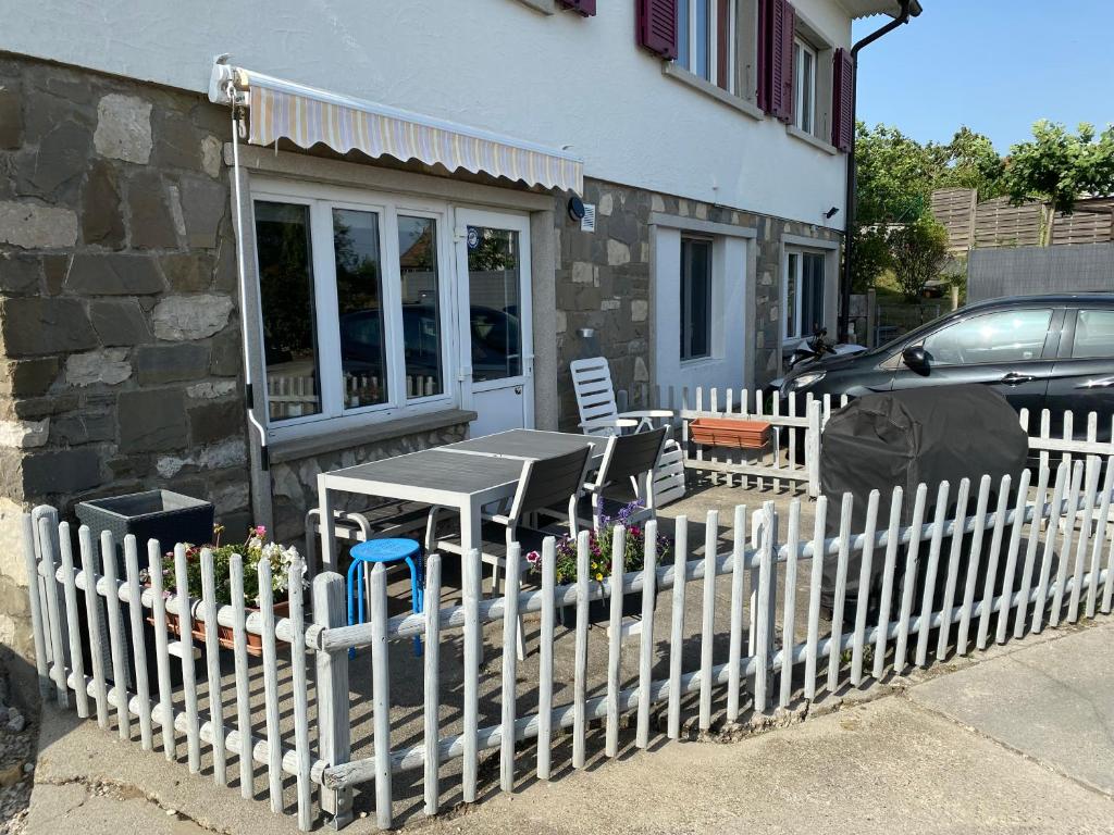 a white fence with a table and chairs in front of a house at Le Clafoutis in Apples