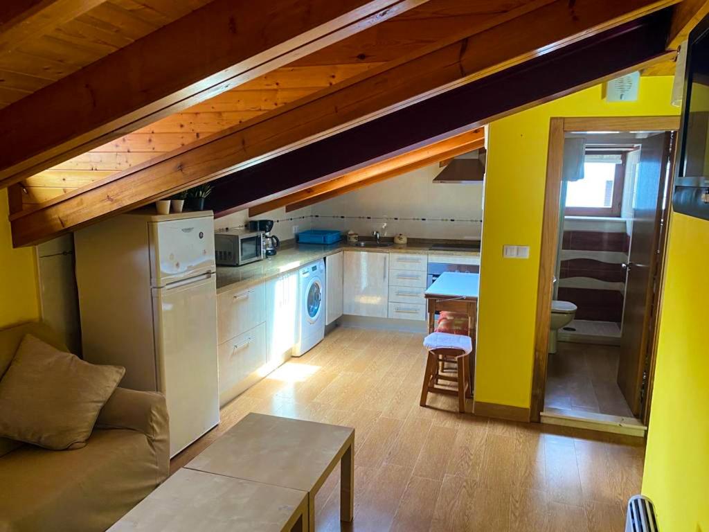 a kitchen with a couch and a table in a room at Casa Lalín, apartamento en Cudillero in Cudillero